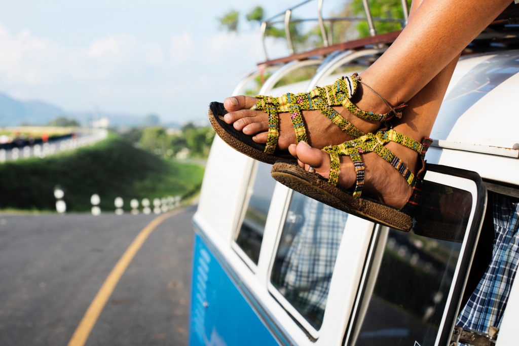 women with sandals on atop a vw bus