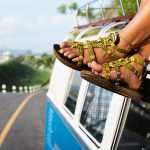 women with sandals on atop a vw bus